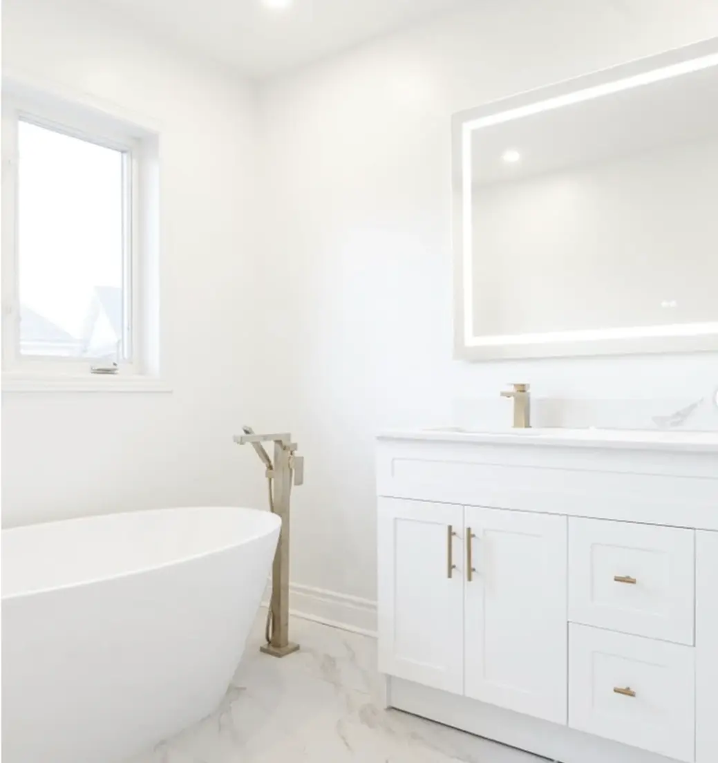 Bathroom with a freestanding soaker tub and white vanity near Pickering