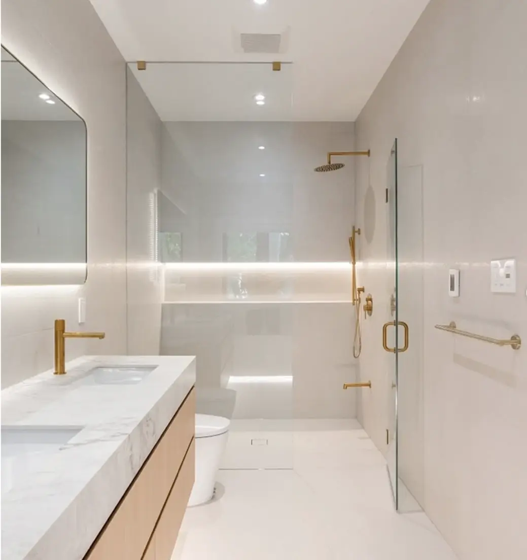Narrow bathroom with brass fixtures and a floating vanity near Waterloo