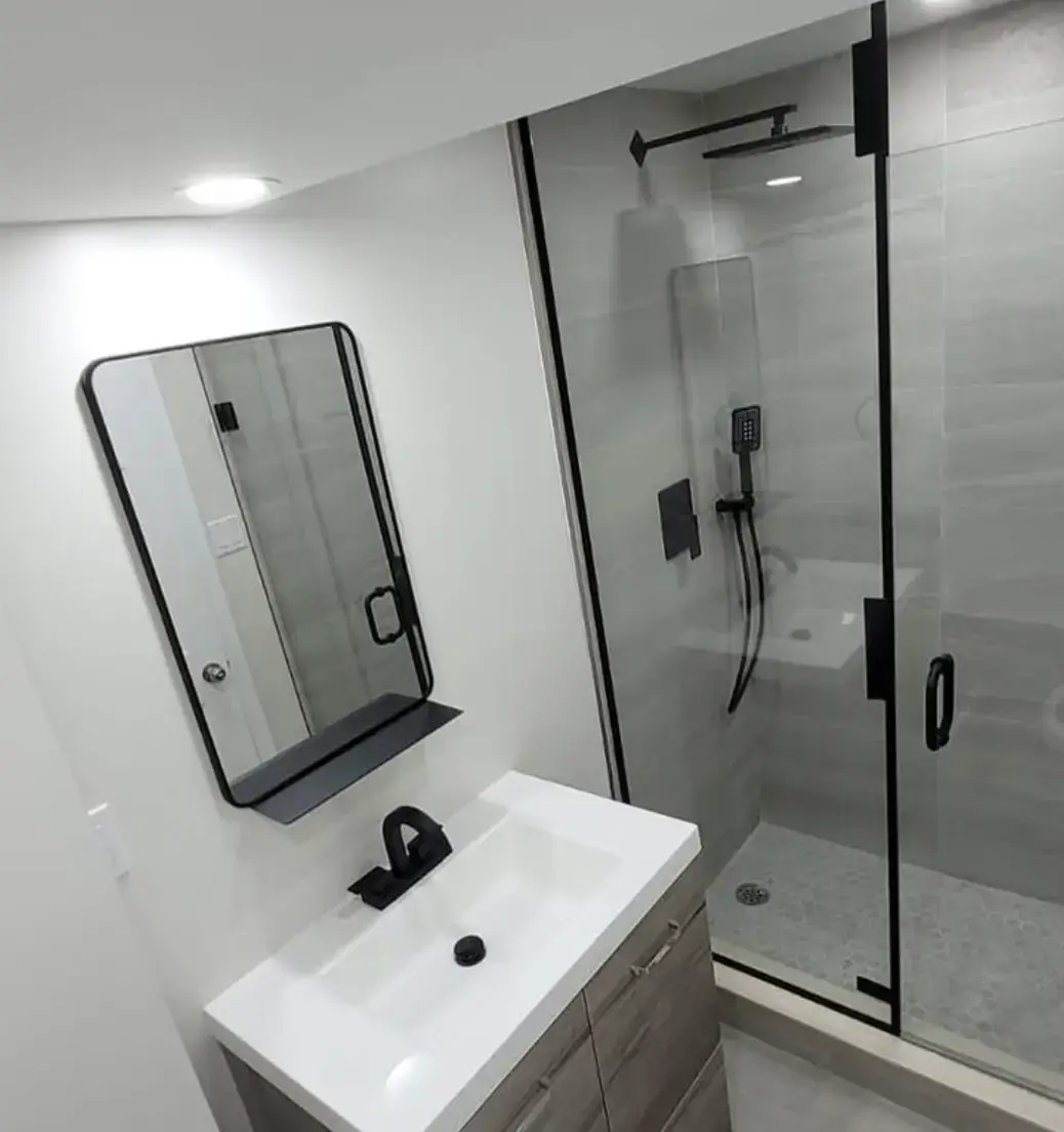 Bathroom with a black framed mirror and glass shower enclosure near Orangeville