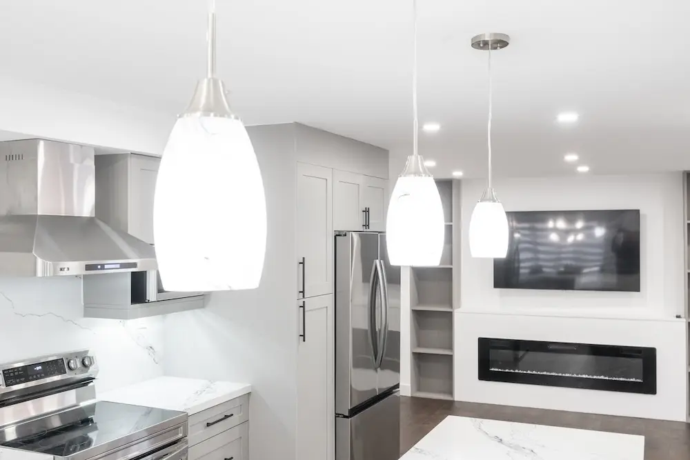 White kitchen with pendant lighting and a built-in fireplace in a Pickering home