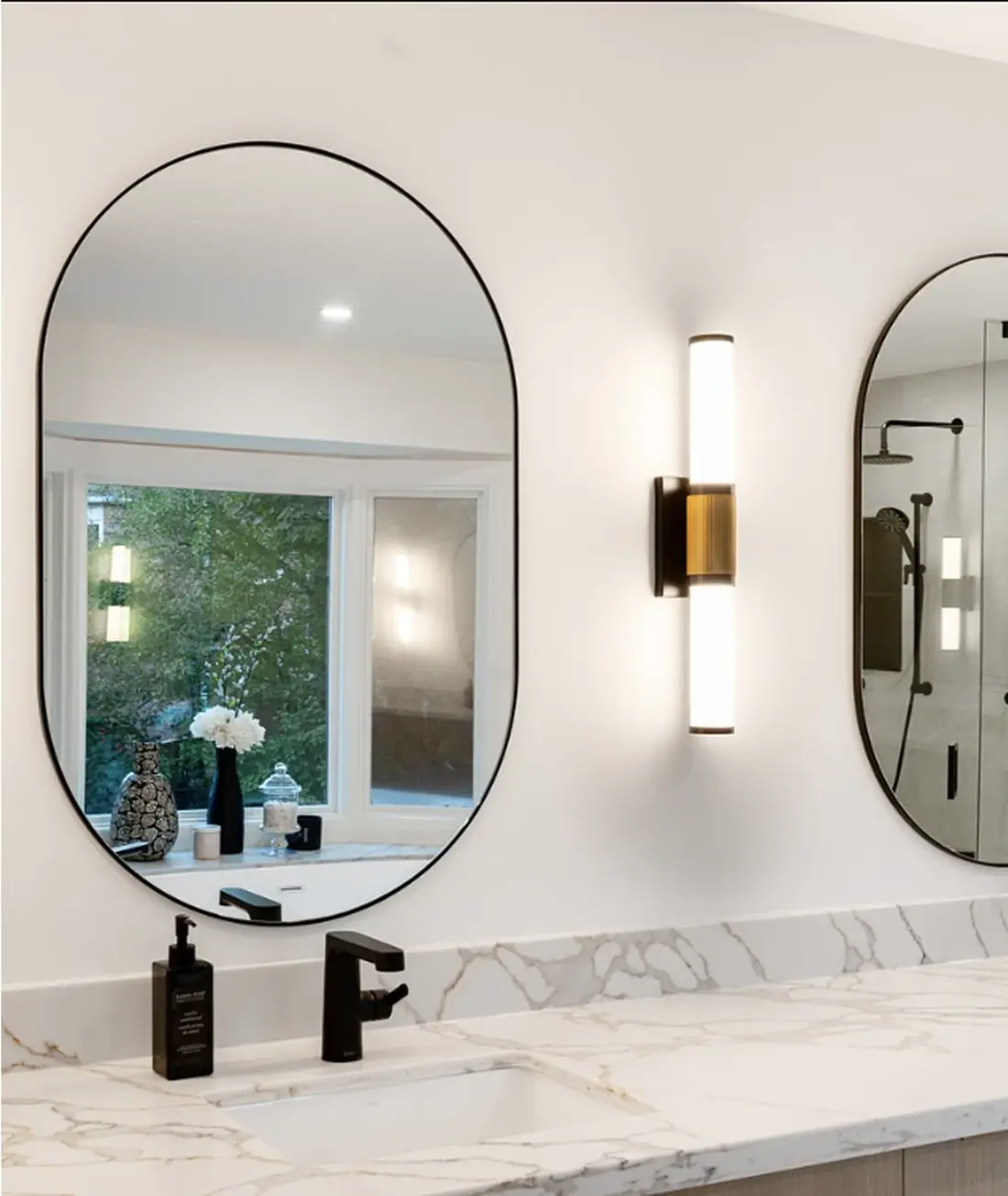 Bathroom with double oval mirrors and a marble vanity near Caledon