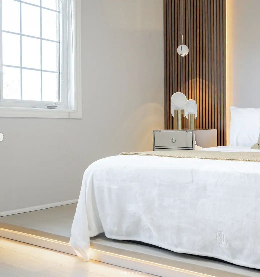 Bedroom with a slatted wood wall and soft lighting near Oshawa