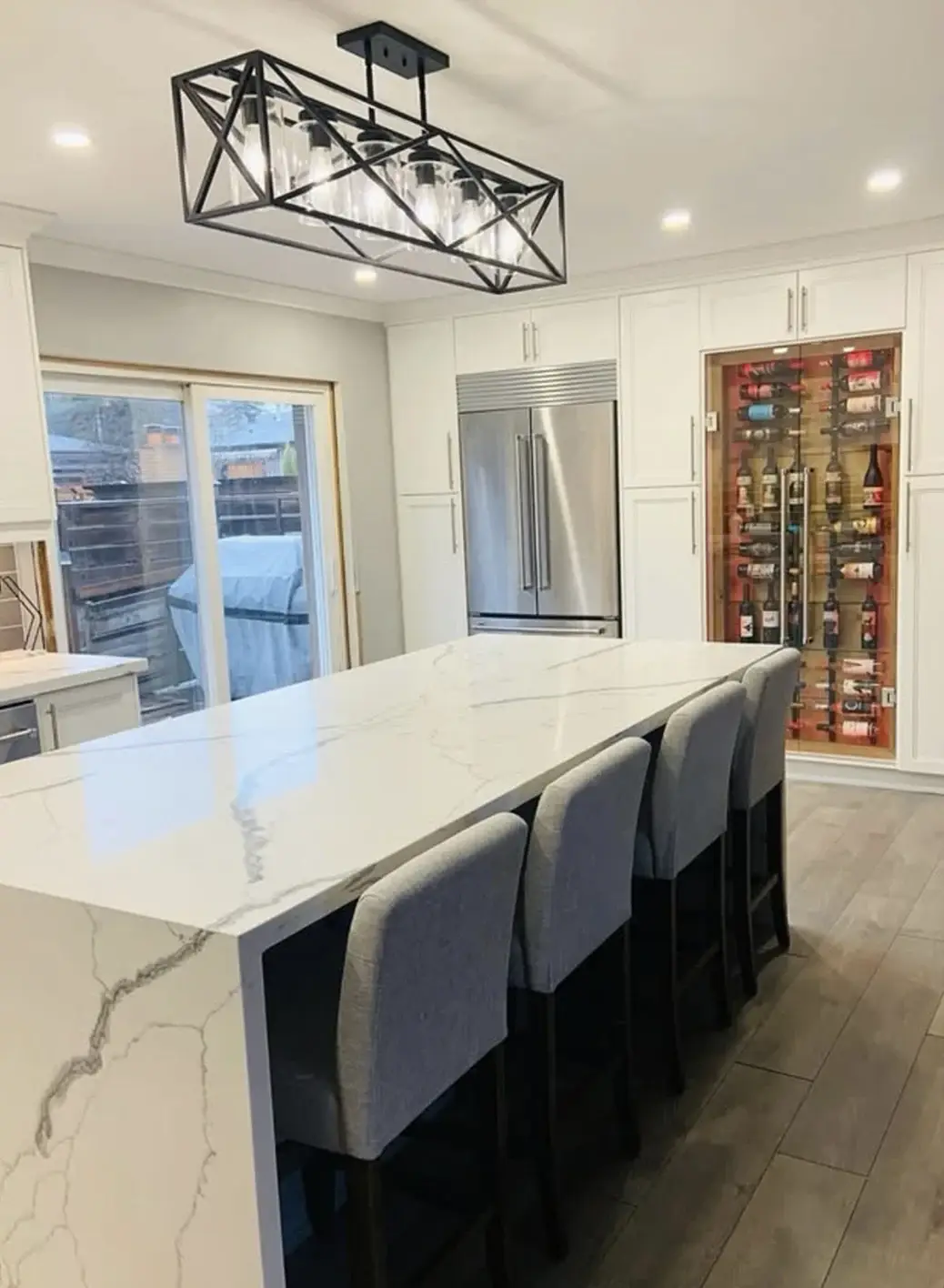 Marble island with bar seating and a built-in wine display near Caledon