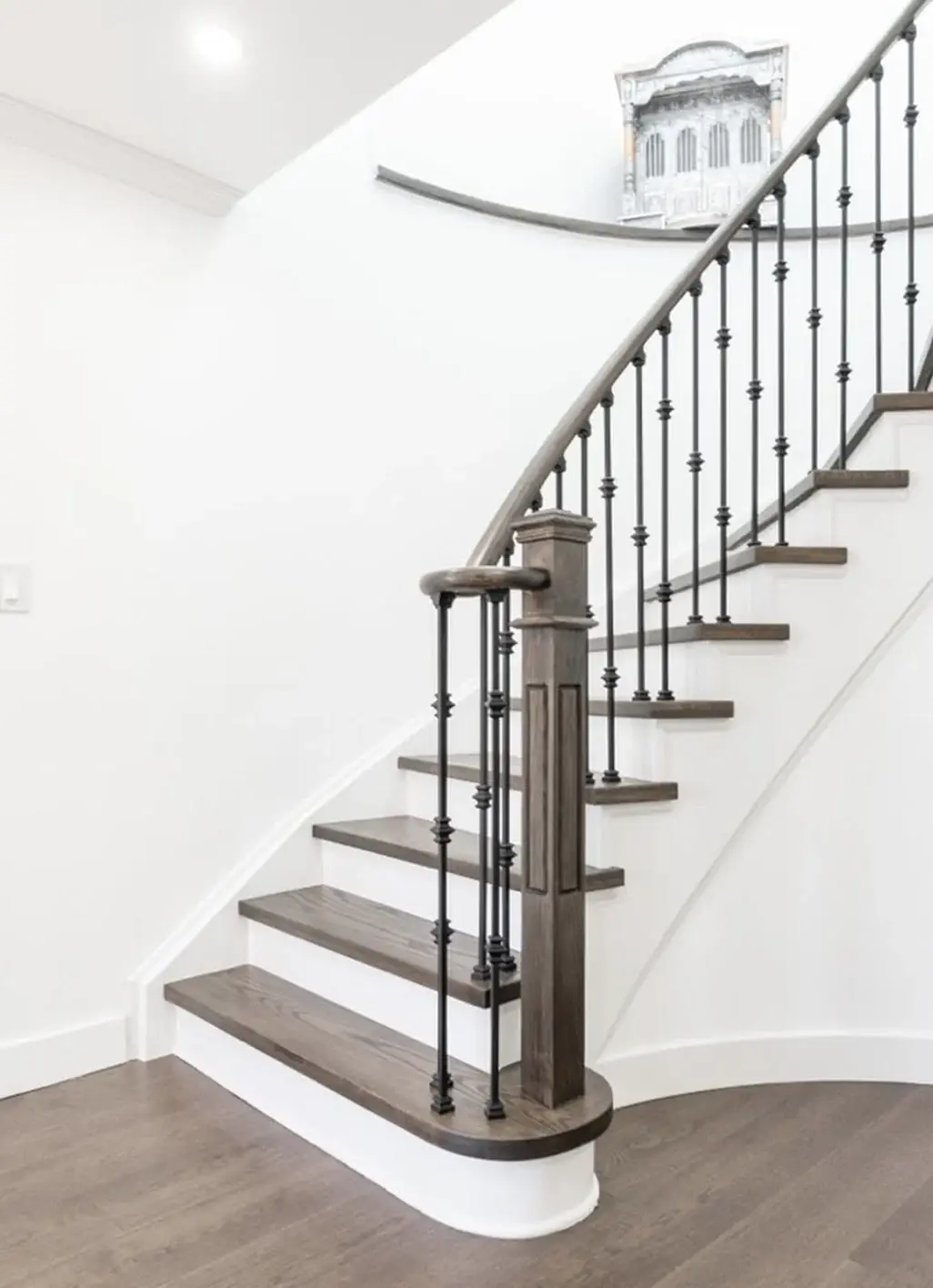 Refinished staircase with wrought iron railings in a Milton home