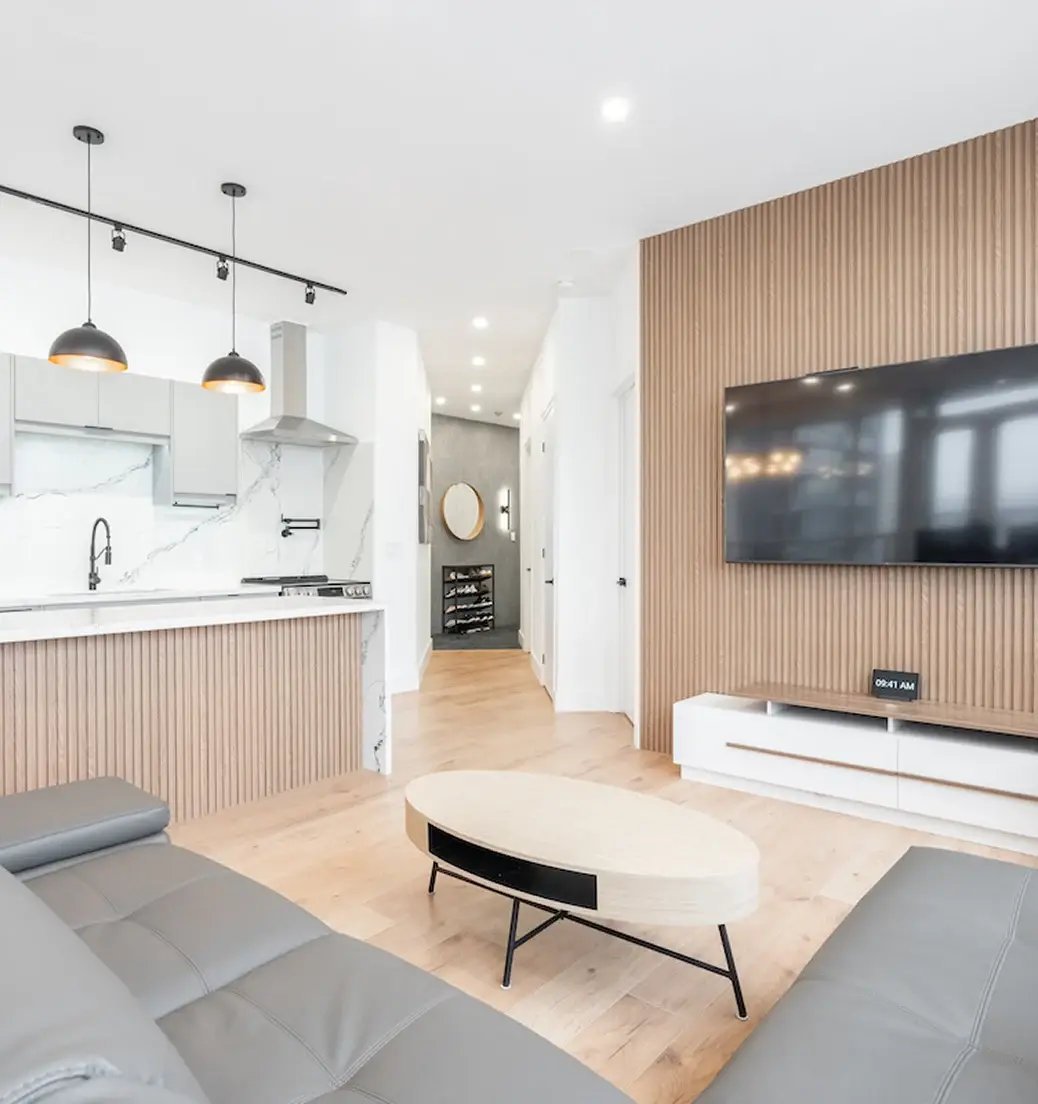 Open kitchen and living space with a wood slat television wall near Caledon