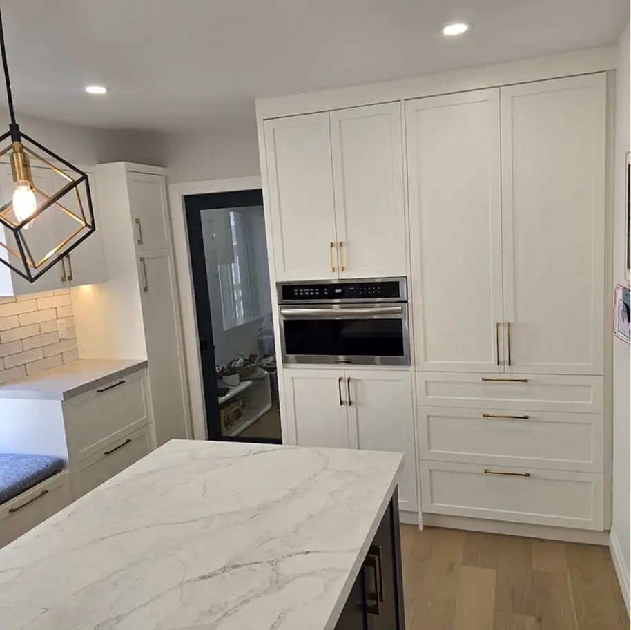 White kitchen with a marble waterfall island and geometric pendant near Innisfil