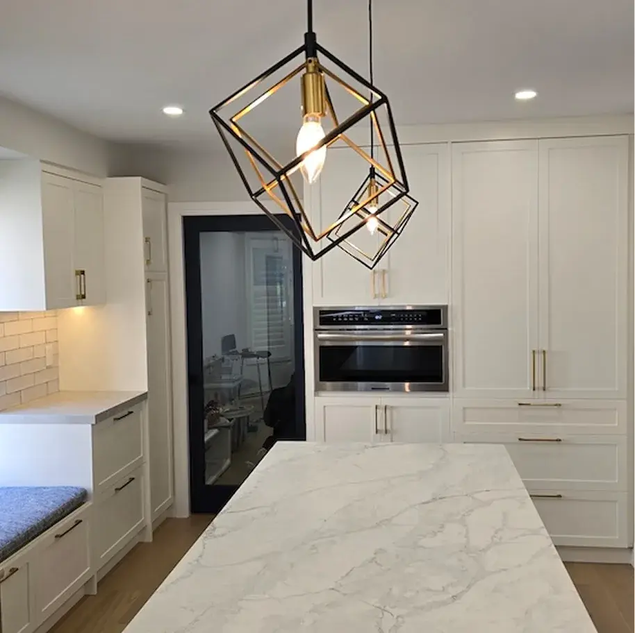 White kitchen with marble countertops and a geometric pendant light in a Georgetown home
