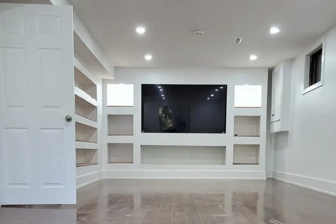 Finished basement with built-in shelving and a wall-mounted television near Waterloo