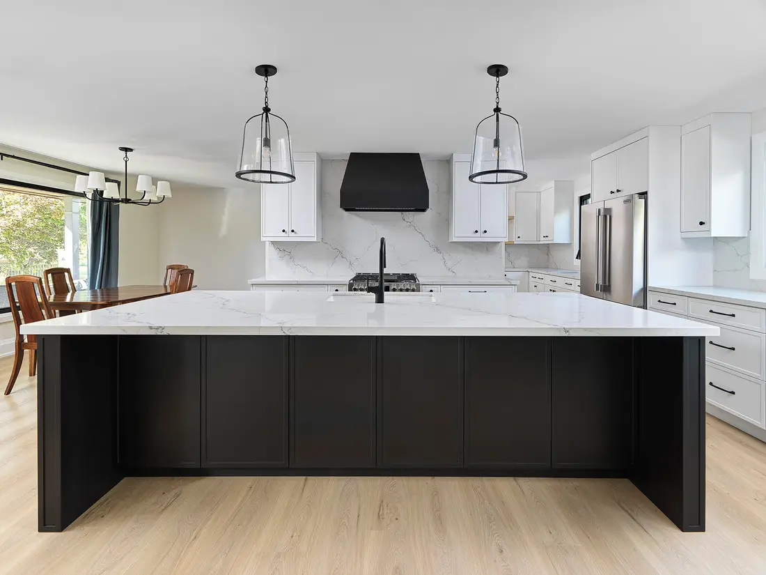 Renovated kitchen with a dark island and white cabinetry in a Guelph home