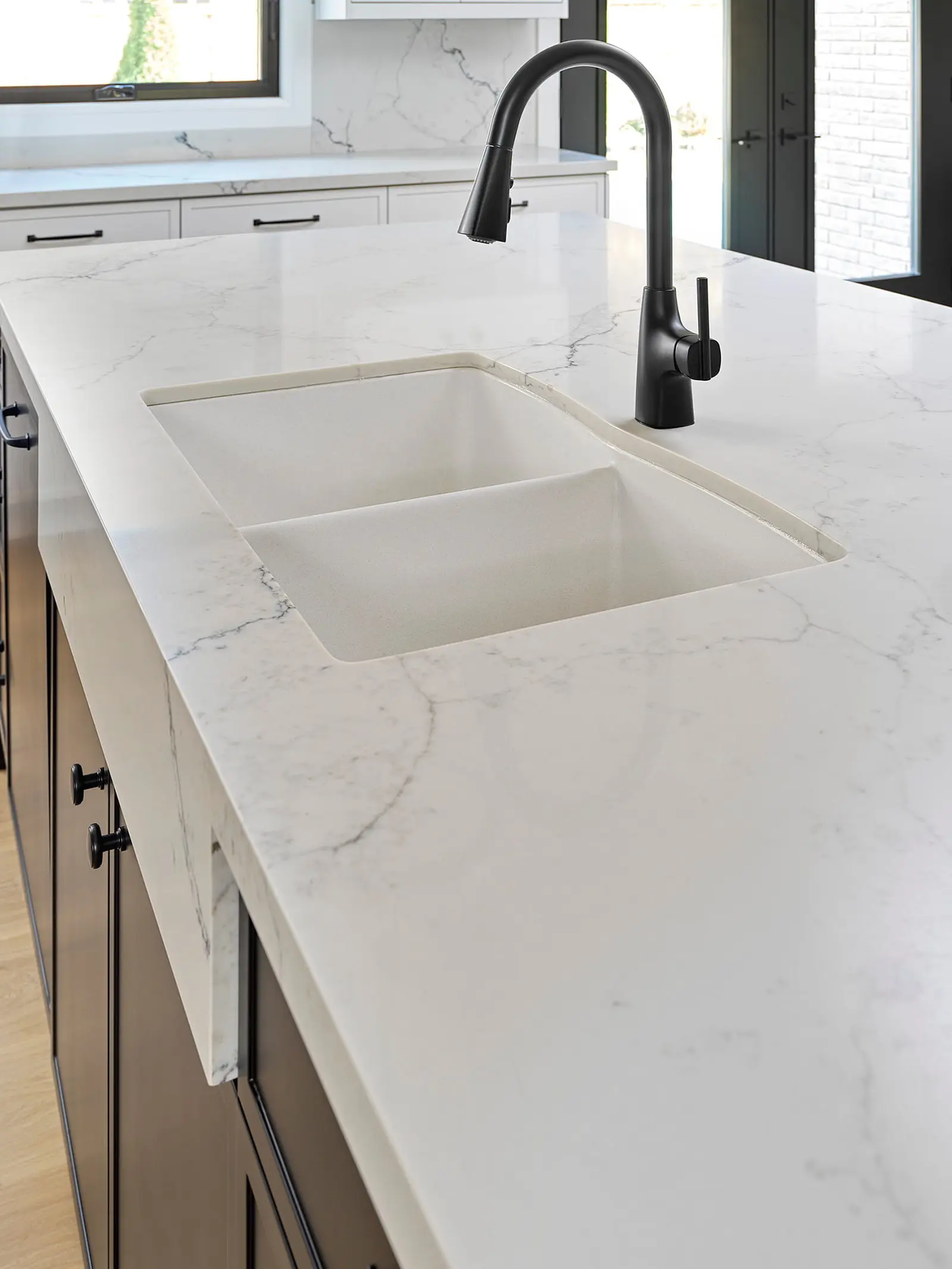 Undermount sink and black faucet set in a quartz counter