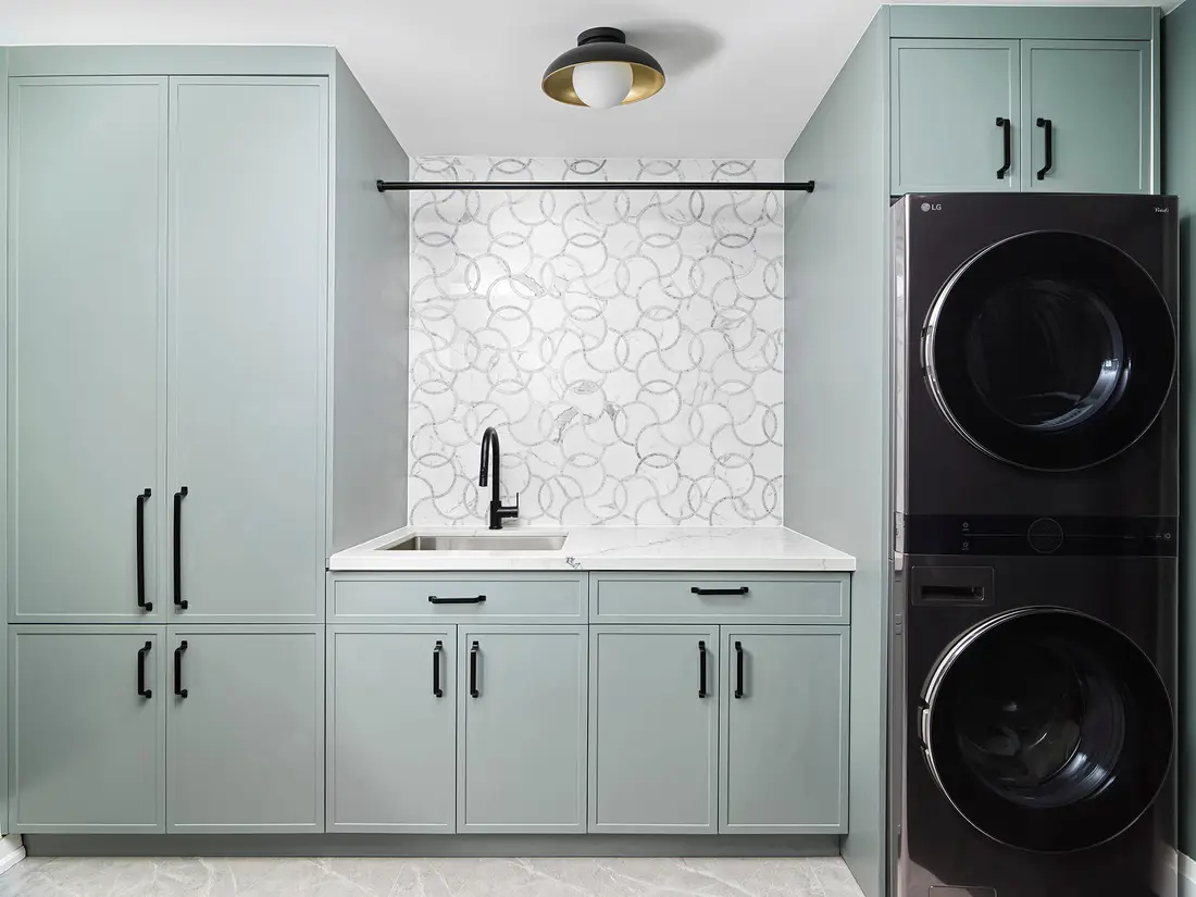 Laundry and mudroom with sage cabinetry and stacked machines near Georgetown