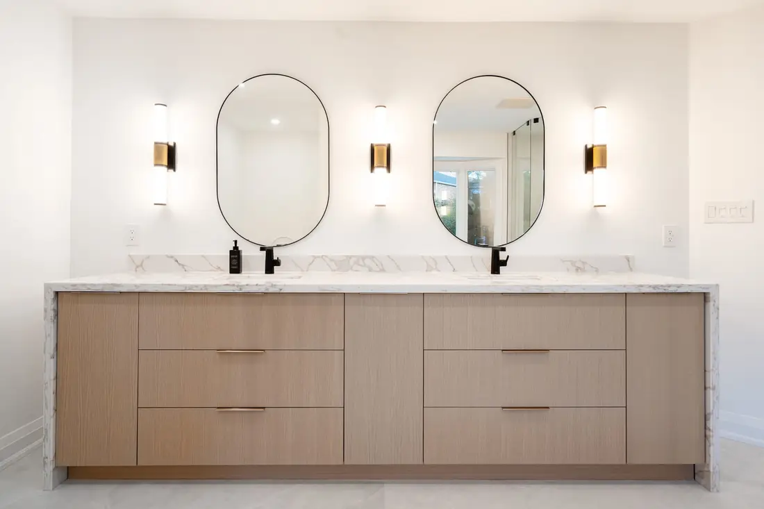 Double vanity with wood cabinetry and oval mirrors near Halton Hills