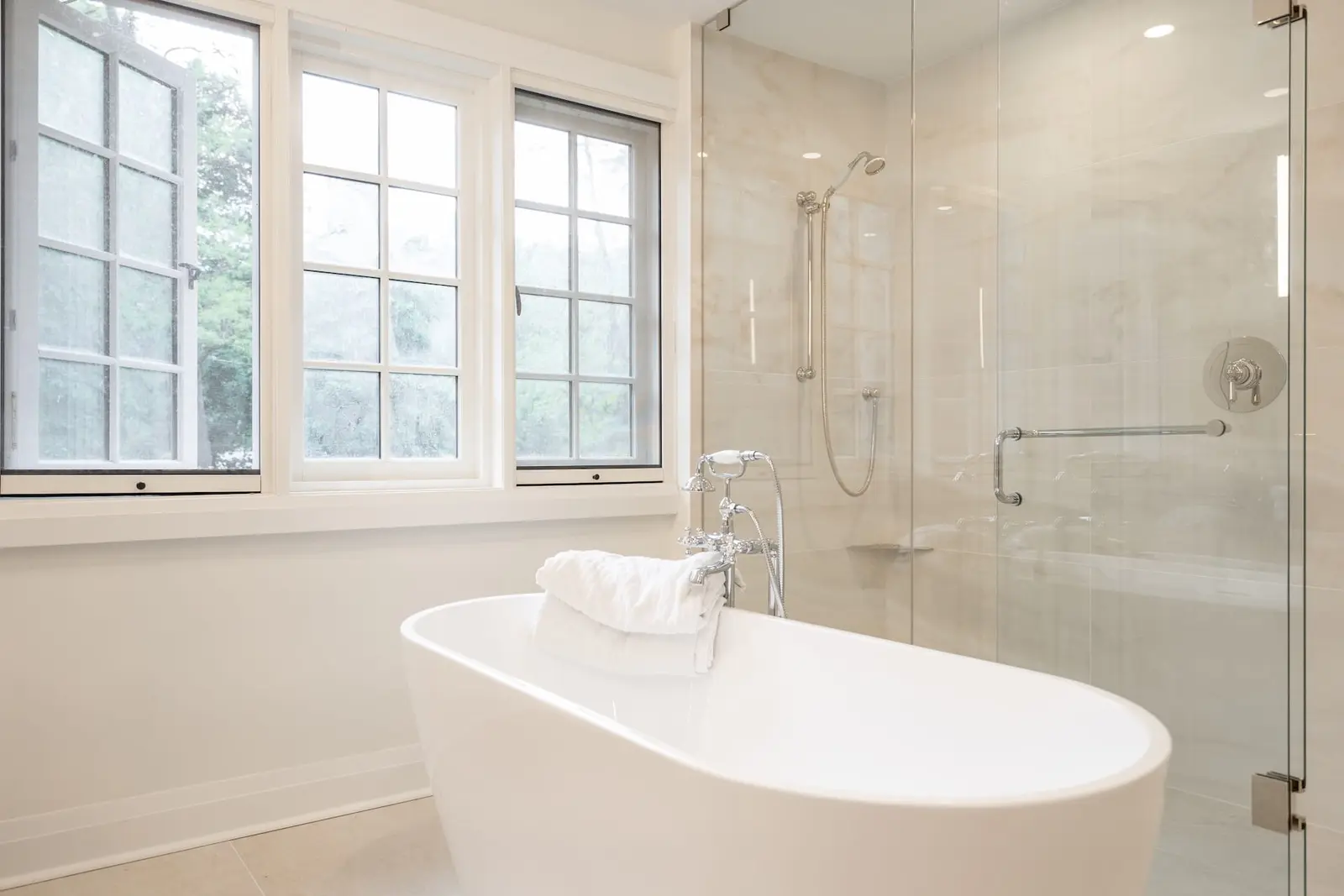 Bright ensuite with a freestanding tub and glass shower
