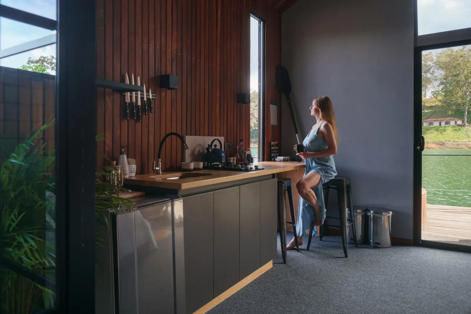 Compact kitchen with a wood slat wall and bar seating inside a backyard suite