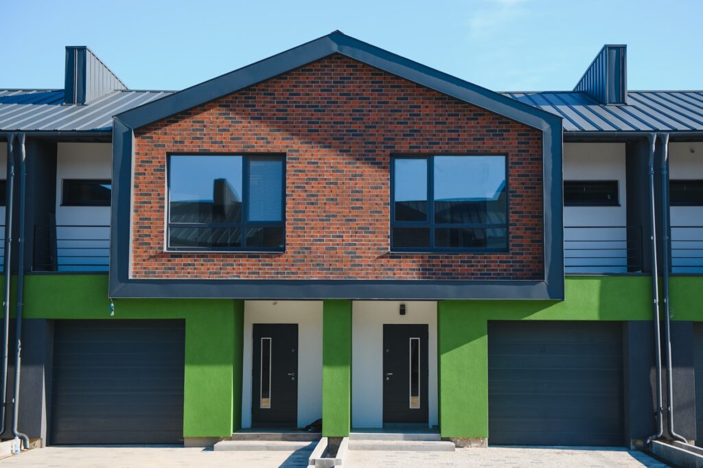 Two-unit multiplex building Multi-unit building with two front entrances and brick upper storey